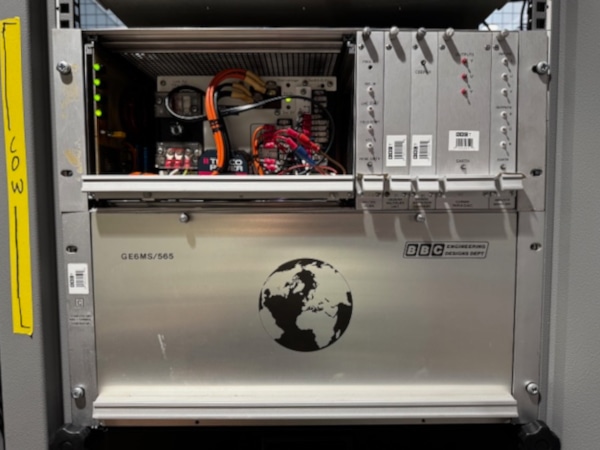 Silver globe player box with the front cover at the top removed, exposing wiring inside