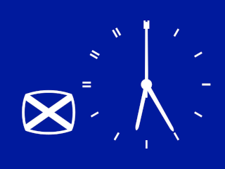 White on blue analogue clock with Scottish flag bottom left