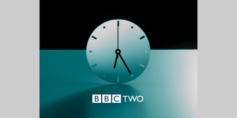 Clock with BBC TWO underneath on a black and teal background